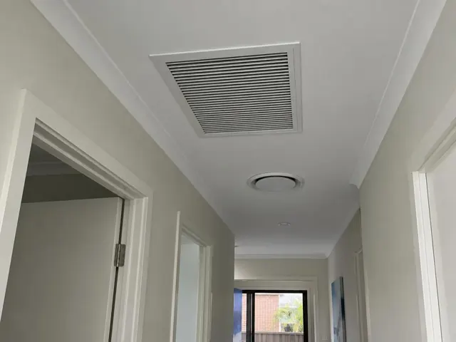 Ceiling return-air grille in a hallway with white walls and door frames in Surfers Paradise